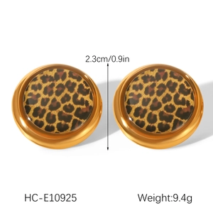 Detail view of round 18K gold earrings with leopard print and 2.3cm size measurement