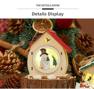 Detail of a lit wooden Christmas house ornament with snowman pattern and pine cone decor