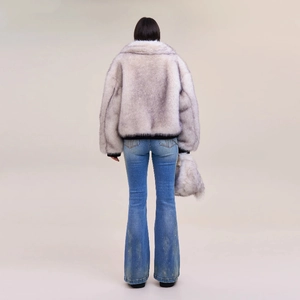 Detailed back view of flared jeans paired with a plush faux fur coat and matching handbag