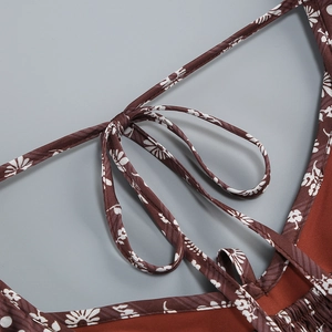 Close-up of the vintage brown floral dress featuring a tie-up bow and woven fabric detail