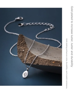 Detail of silver star pendant with zircon on stone, showcasing real gold plating texture