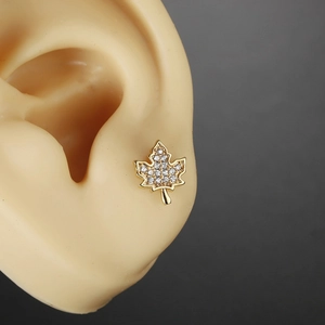 Golden maple leaf stud earring with sparkling cubic zirconia on ear model