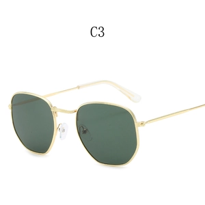 Detail view of gold metal frames and dark green hexagonal lenses of stylish retro sunglasses