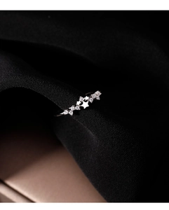 Dettaglio macro di un anello a stella in argento sterling con zirconi su seta nera