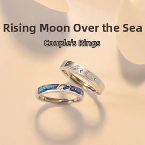Detailed view of angel wing couple rings with blue enamel waves and moon design