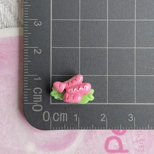 Macro view of miniature resin sausage and lettuce food model charm for DIY crafts