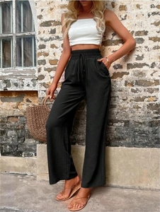 Détail de la taille haute élastique avec cordon de serrage sur un pantalon large noir