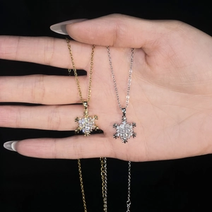 Close-up of gold and silver snowflake pendants with sparkling zircon crystal stones