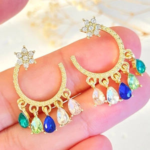 Detailed view of moon and star tassel earrings with vibrant multi-color teardrop gems