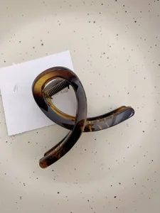 Détail du grand clip à cheveux en acétate écaille de tortue au design croisé élégant