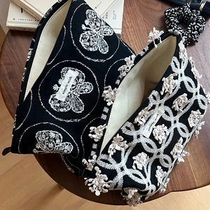 Détails de broderie de papillon blanc et dentelle florale sur sacs en toile noire