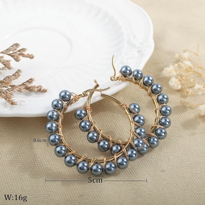 Detail view of handmade 5cm gold hoop earrings with 0.6cm grey pearls and wire wrapping