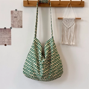 Detail of vintage green floral pattern and wide shoulder strap on a large canvas tote bag