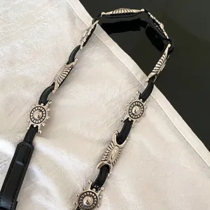 Close-up of vintage silver butterfly chain belt with geometric oval metal elements