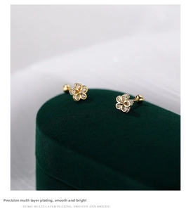 Macro view of gold-plated S925 sterling silver flower stud earrings with threaded ball back
