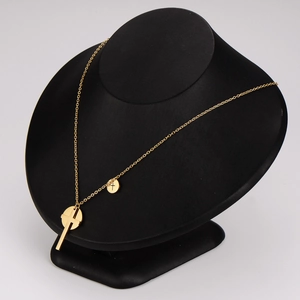 Gold stainless steel cross pendant necklace with round disc charm on a black display bust