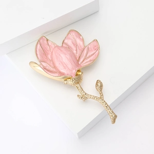 Detailed view of pink enamel magnolia flower brooch with elegant gold metal stem