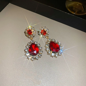 Gros plan sur les boucles d'oreilles vintage en or avec pierres rouges et cristaux