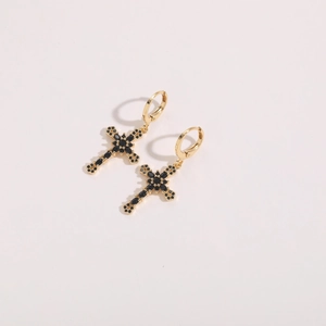 Detail of 14K gold plated hoop earrings with black zircon cross charm on white background