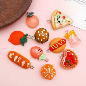 Flat lay of resin food pendants including orange, burger and pizza for DIY jewelry