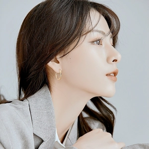 Minimalist gold hoop earrings for women in polished stainless steel on a female model