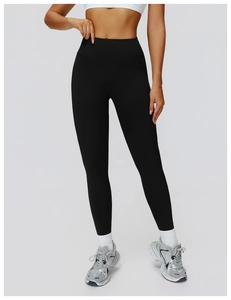 Detail of black high-waisted seamless yoga pants with compression fabric for body shaping