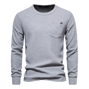 Macro detail of men's gray waffle texture long sleeve shirt showing chest pocket and fabric