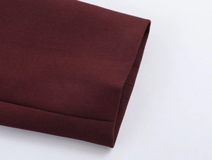 Close-up of the textured burgundy fabric and fine stitching detail on the sleeve cuff