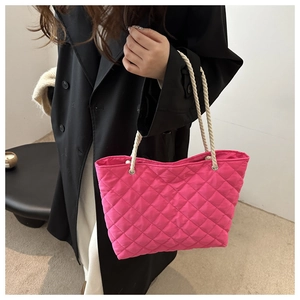 Detail of rose red quilted tote bag with white cotton rope handles and diamond stitching