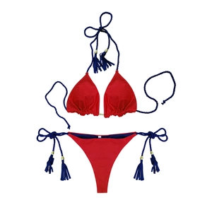 Detail of red bikini with blue tassel ties and size S label on white background