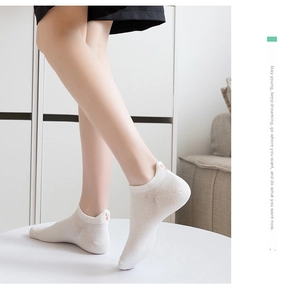 Detail showing white low-cut cotton socks with cute heart embroidery on the heel