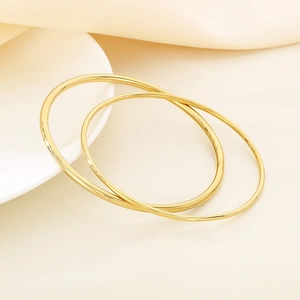 Detailed view of two stacked 2mm and 3mm minimalist gold stainless steel bangles
