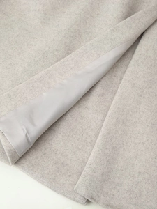 Détail de la texture en laine et de la doublure lisse sur un long manteau d'hiver