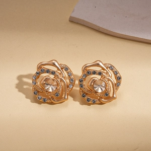 Macro detail of hollow rose flower stud earring with grey crystals and gold plating