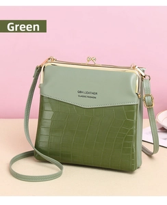 Close-up of green crocodile texture and smooth leather stitching with gold hardware
