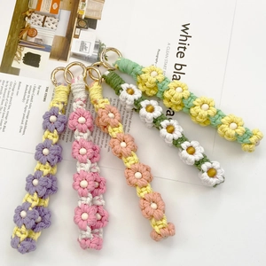 Five handmade woven daisy flower keychains with wooden beads and gold metallic clips