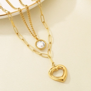 Detail of gold double-layer necklace with paperclip chain and heart pendant