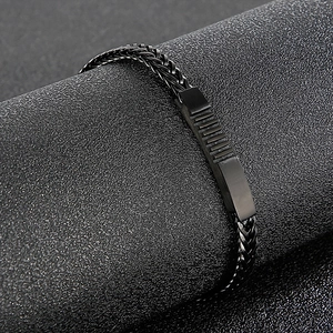 Close-up of black stainless steel woven chain bracelet with matte magnetic clasp for men
