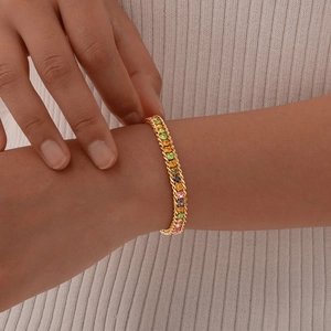 Detailed close-up of a gold chain bracelet with vibrant square-cut rainbow gemstones