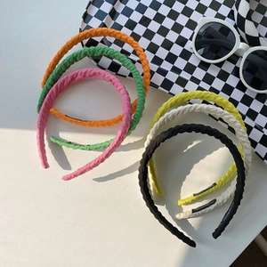 Detailed view of colorful twisted resin headbands in orange, green, and pastel shades