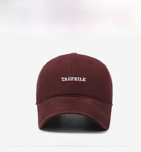 Detailed close-up of white TAOFEILE embroidery on a washed cotton burgundy baseball cap