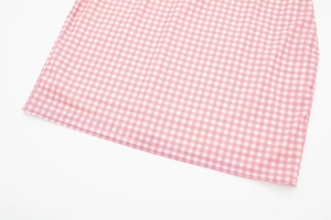 Detailed view of pink and white checkered fabric with precise edge stitching
