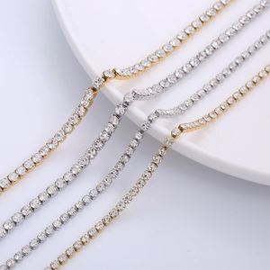 Glistening gold and silver tennis chain necklaces with cubic zirconia on a white plate