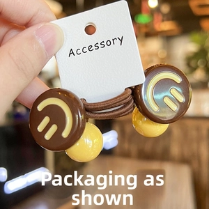 Detailed view of elastic hair ties featuring smiley face beads and accessory card