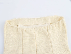 Nahaufnahme des unsichtbaren Reißverschlusses am strukturierten beigefarbenen Kleid