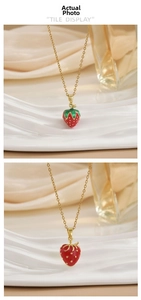 Detailed view of red and green strawberry pendant necklace with gold chain and enamel finish