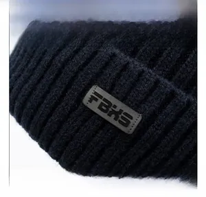 Macro shot of dark blue knit beanie fabric texture with FBHS leather logo patch detail