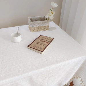 Détail d'une nappe en coton et lin blanc avec texture gaufrée et bordures à franges