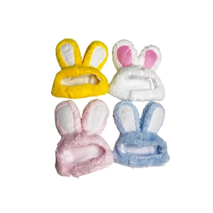 Flat lay of soft plush rabbit ear hats for cats and dolls in yellow white pink and blue