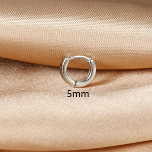 Detailed close-up of 5mm minimalist sterling silver hoop earring on champagne silk background